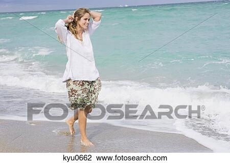 Woman walking on the beach View Large Photo Image Stock Image - Woman walking on the beach. Fotosearch