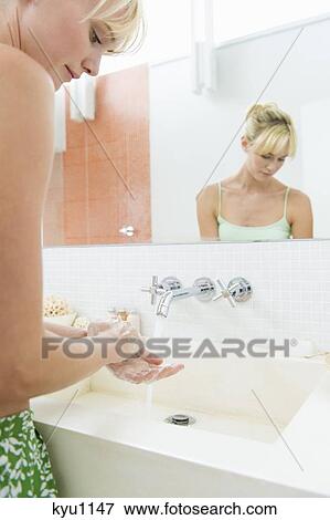 Stock Photo - Woman washing hands in the bathroom. Fotosearch