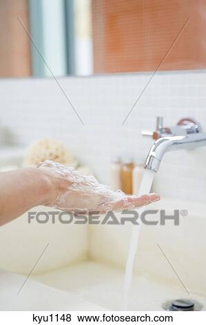 Stock Photo - Woman washing hands in the bathroom. Fotosearch