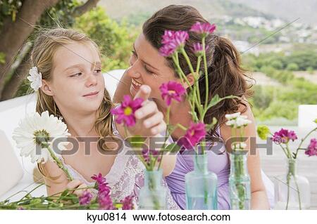 Woman with her daughter arranging flowers in a vase View Large Photo Image Picture - Woman with her daughter arranging flowers in a vase. Fotosearch