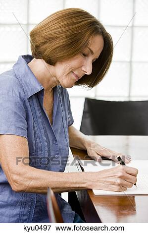 Stock Photo - Woman writing in a notebook. Fotosearch