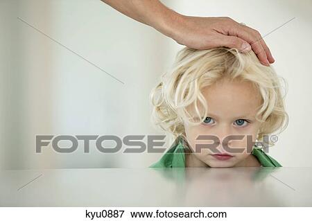 Stock Photo - Woman's hand on her daughter's head. Fotosearch