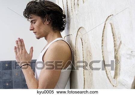Young man with folded hands, closed eyes View Large Photo Image Stock Photography - Young man with folded hands, closed eyes. Fotosearch