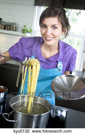 Young smiling woman cooking pasta View Large Photo Image Stock Image - Young smiling woman cooking pasta. Fotosearch