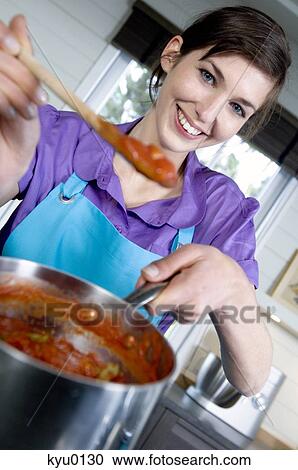 Young smiling woman cooking tomato sauce View Large Photo Image Stock Image - Young smiling woman cooking tomato sauce. Fotosearch