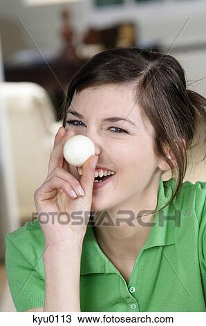 Young smiling woman covering her nose with hard boiled egg View Large Photo Image Stock Image - Young smiling woman covering her nose with hard boiled egg. Fotosearch