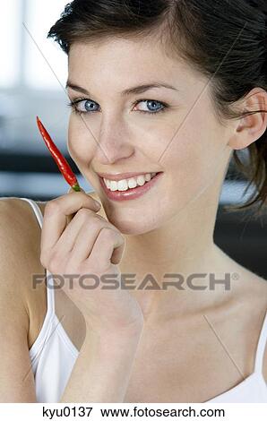 Young smiling woman holding red pepper View Large Photo Image Stock Photo - Young smiling woman holding red pepper. Fotosearch