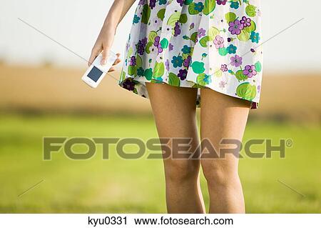 Stock Image - Young woman holding a cell, detail. Fotosearch