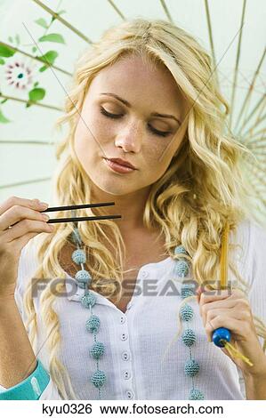 Young woman holding chopsticks and umbrella View Large Photo Image Stock Photograph - Young woman holding chopsticks and umbrella. Fotosearch