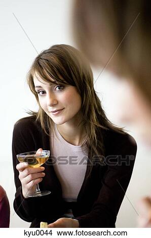Picture - Young woman holding glass of champagne. Fotosearch