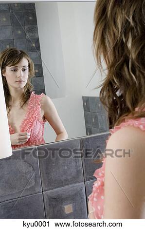 Young woman in nightgown in front of bathroom mirror View Large Photo Image Stock Image - Young woman in nightgown in front of bathroom mirror. Fotosearch