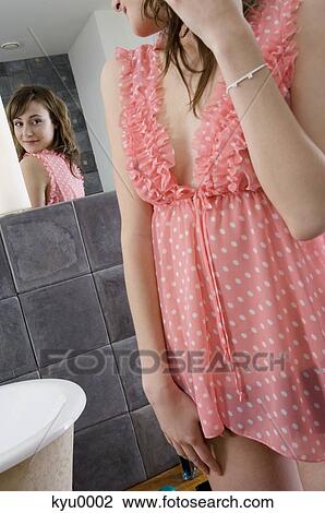 Young woman in nightgown in front of bathroom mirror View Large Photo Image Stock Image - Young woman in nightgown in front of bathroom mirror. Fotosearch