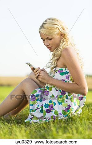 Stock Photo - Young woman looking at her cell. Fotosearch