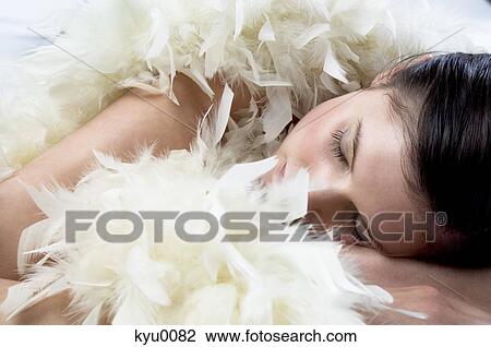 Young woman sleeping with white feather boa View Large Photo Image Stock Image - Young woman sleeping with white feather boa. Fotosearch
