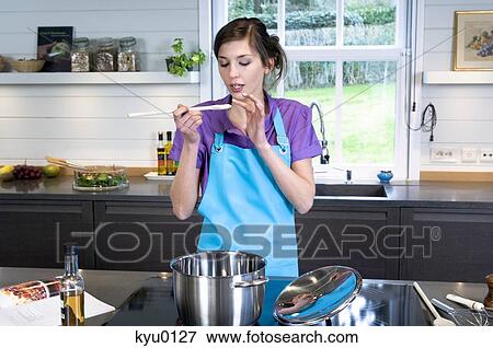 Stock Photo - Young woman tasting food. Fotosearch