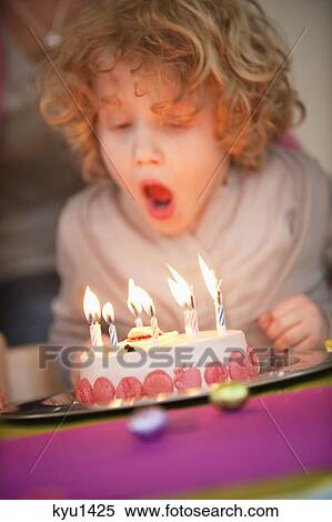 Boy blowing out candles on his birthday cake View Large Photo Image Stock Photography - Boy blowing out candles on his birthday cake. Fotosearch