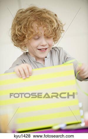 Boy opening his birthday present View Large Photo Image Stock Photo - Boy opening his birthday present. Fotosearch