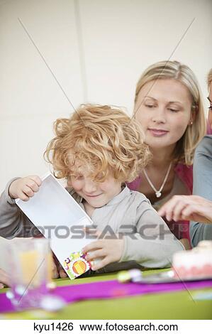 Boy opening his birthday present View Large Photo Image Stock Photograph - Boy opening his birthday present. Fotosearch