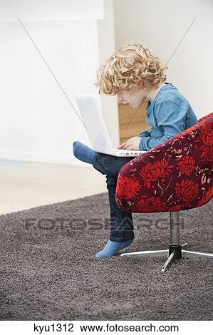 Boy using a laptop View Large Photo Image Stock Image - Boy using a laptop. Fotosearch