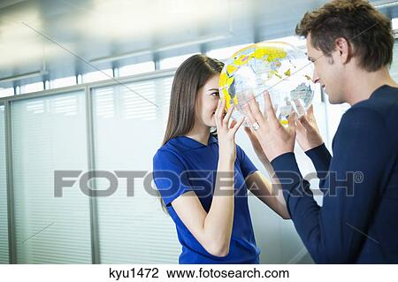 Stock Image - Business couple romancing in an office. Fotosearch