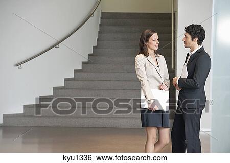 Stock Photograph - Business executives discussing in an office. Fotosearch