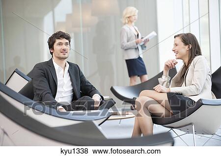 Business executives sitting on chairs in a waiting room View Large Photo Image Stock Photo - Business executives sitting on chairs in a waiting room. Fotosearch