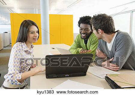 Business executives using laptops in an office View Large Photo Image Stock Image - Business executives using laptops in an office. Fotosearch