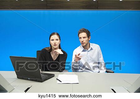 Stock Photography - Business executives working on a laptop in a conference room. Fotosearch
