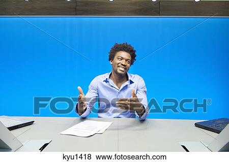 Businessman doing paperwork and smiling in a conference room View Large Photo Image Stock Photo - Businessman doing paperwork and smiling in a conference room. Fotosearch