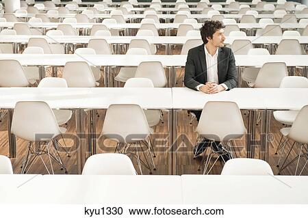 Stock Image - Businessman sitting at a cafeteria and thinking. Fotosearch