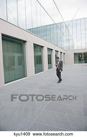 Businessman text messaging on a mobile phone View Large Photo Image Stock Photo - Businessman text messaging on a mobile phone. Fotosearch