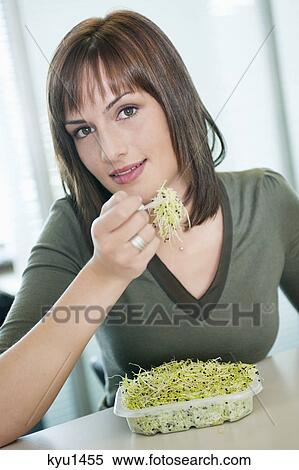 Stock Photography - Businesswoman eating bean sprouts. Fotosearch
