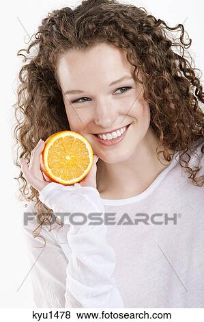 Close-up of a woman holding a half of an orange View Large Photo Image Stock Photo - Close-up of a woman holding a half of an orange. Fotosearch