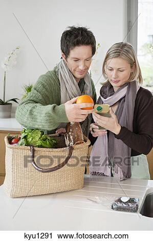 Couple checking groceries at home View Large Photo Image Stock Image - Couple checking groceries at home. Fotosearch