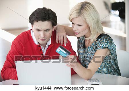 Couple shopping online with a laptop View Large Photo Image Picture - Couple shopping online with a laptop. Fotosearch
