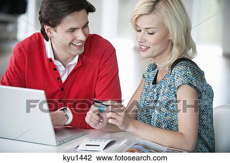 Stock Image - Couple shopping online with a laptop. Fotosearch