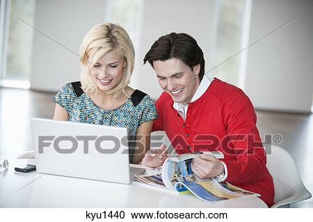 Couple using a laptop and smiling View Large Photo Image Stock Image - Couple using a laptop and smiling. Fotosearch