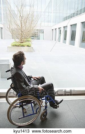 Stock Image - Disabled businessman sitting in a wheelchair. Fotosearch