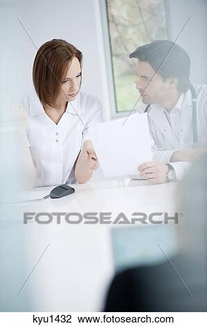 Stock Image - Doctors discussing a medical report. Fotosearch