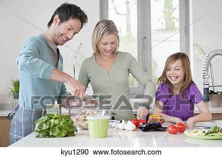 Stock Image - Family preparing food in the kitchen. Fotosearch