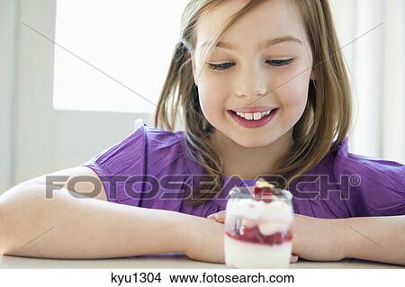 Girl looking at a glass of ice cream View Large Photo Image Picture - Girl looking at a glass of ice cream. Fotosearch