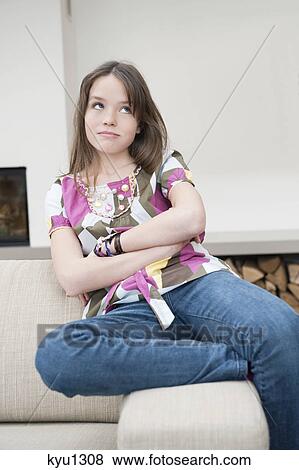 Stock Photo - Girl sitting on a couch. Fotosearch