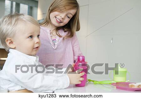 Stock Image - Girl smiling with her brother. Fotosearch