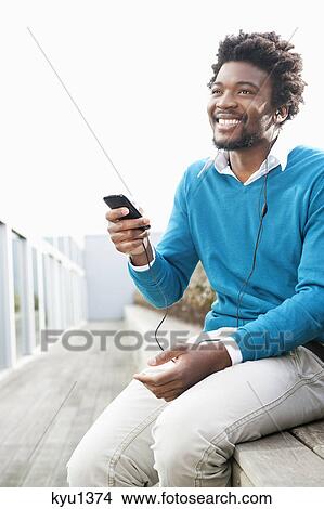 Man listening to an MP3 player View Large Photo Image Picture - Man listening to an MP3 player. Fotosearch