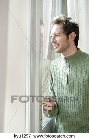 Man looking out through a door glass View Large Photo Image Stock Photo - Man looking out through a door glass. Fotosearch
