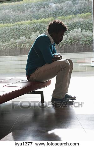 Man sitting on a couch and thinking View Large Photo Image Stock Photo - Man sitting on a couch and thinking. Fotosearch
