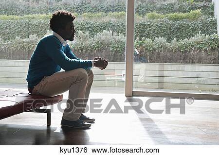 Man sitting on a couch and thinking View Large Photo Image Stock Photograph - Man sitting on a couch and thinking. Fotosearch