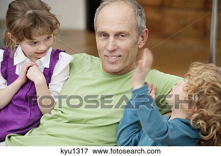 Man sitting with his grandchildren View Large Photo Image Stock Photo - Man sitting with his grandchildren. Fotosearch
