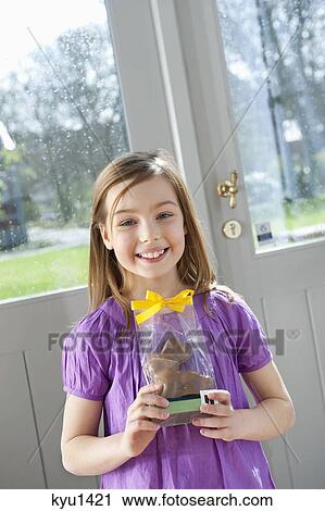 Portrait of a girl holding an Easter bunny and smiling View Large Photo Image Stock Image - Portrait of a girl holding an Easter bunny and smiling. Fotosearch