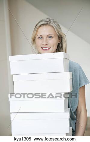Stock Photography - Portrait of a woman carrying shoe boxes. Fotosearch